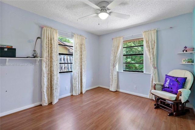 8250 NW 51st Ct, Lauderhill, FL 33351 - living area featuring wood finished floors, plenty of natural light, a ceiling fan, and a textured ceiling