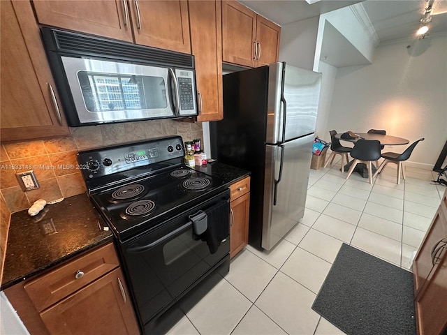 2000 N Bayshore Dr Unit 1505, Miami, FL 33137 - kitchen with stainless steel appliances, light tile patterned floors, tasteful backsplash, brown cabinetry, and crown molding