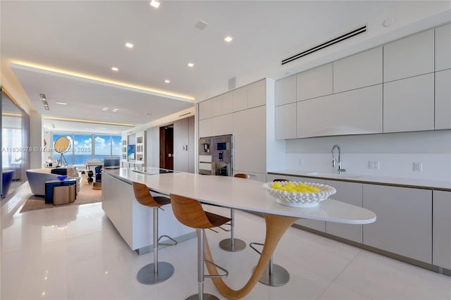 16901 Collins Ave Unit 2702, Sunny Isles Beach, FL 33160 - kitchen featuring modern cabinets, a kitchen breakfast bar, light tile patterned floors, light countertops, and recessed lighting