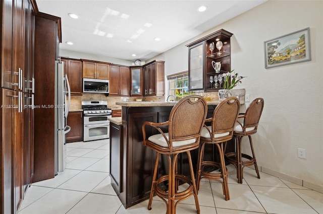 5194 NW 106th Ave, Doral, FL 33178 - kitchen featuring stainless steel appliances, a kitchen bar, tasteful backsplash, open shelves, and light tile patterned floors