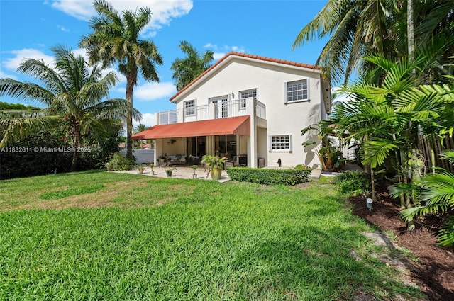 5194 NW 106th Ave, Doral, FL 33178 - back of property with a balcony, stucco siding, a patio, a lawn, and a tile roof