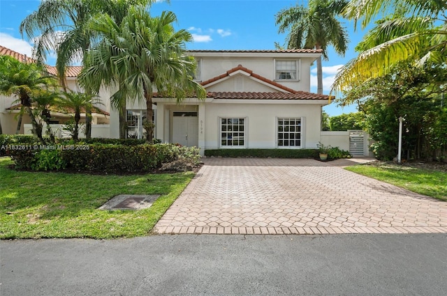 5194 NW 106th Ave, Doral, FL 33178 - mediterranean / spanish-style home with stucco siding, a tile roof, decorative driveway, and a front yard