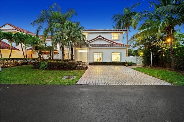 5194 NW 106th Ave, Doral, FL 33178 - mediterranean / spanish-style house with a tile roof, decorative driveway, stucco siding, and a front lawn