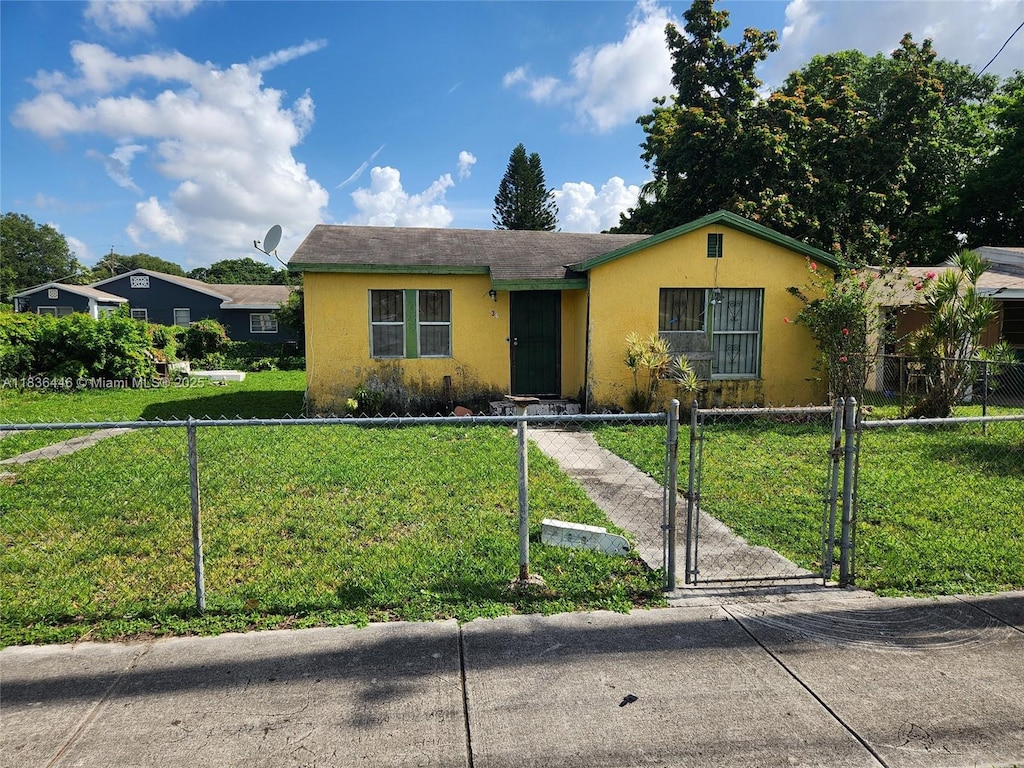 2365 NW 79th Ter, Miami, FL 33147 - single story home featuring stucco siding, a gate, and a fenced front yard