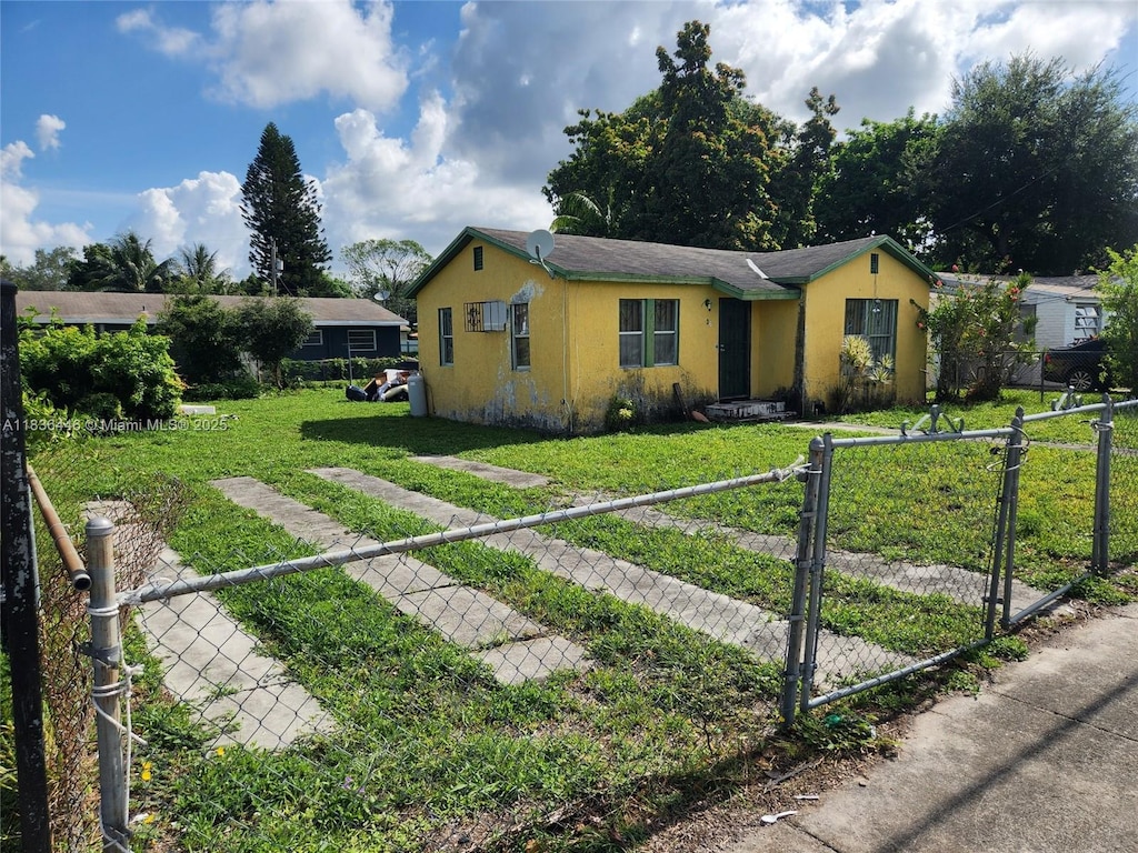 2365 NW 79th Ter, Miami, FL 33147 - ranch-style home with a fenced front yard, stucco siding, and a gate