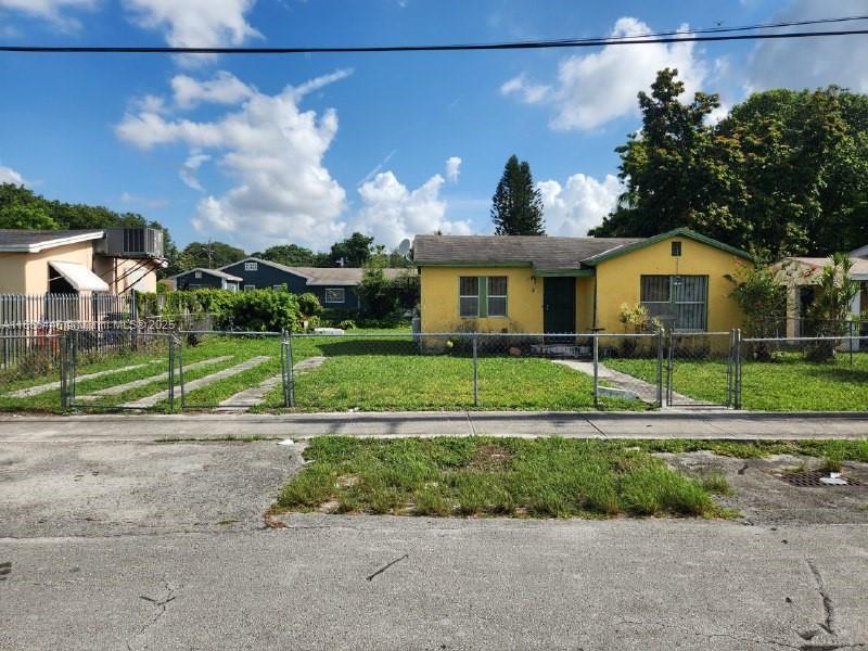 2365 NW 79th Ter, Miami, FL 33147 - ranch-style home with stucco siding and a fenced front yard