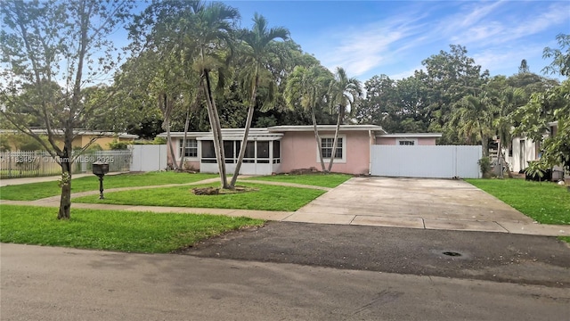 841 NE 139th St, North Miami, FL 33161 - view of front facade featuring driveway, a gate, stucco siding, and a sunroom