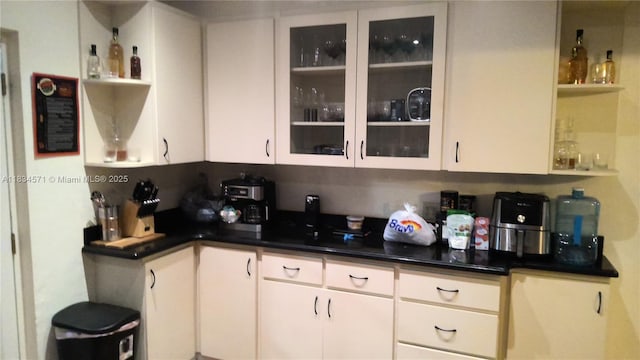 841 NE 139th St, North Miami, FL 33161 - kitchen featuring open shelves, dark countertops, glass insert cabinets, and white cabinets