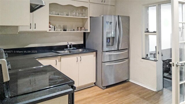 841 NE 139th St, North Miami, FL 33161 - kitchen featuring stainless steel refrigerator with ice dispenser, light wood-type flooring, dark countertops, black range with electric cooktop, and open shelves