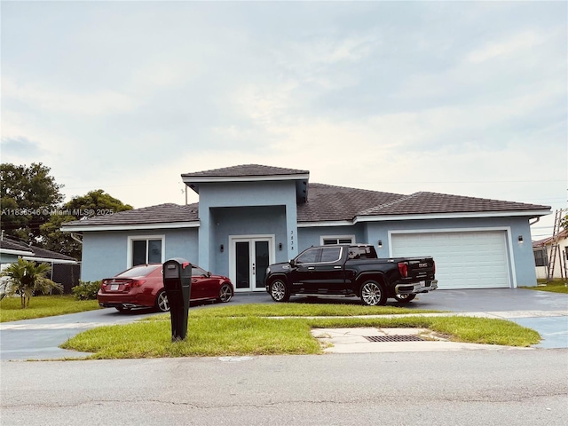 3838 NW 5th Ct, Lauderhill, FL 33311 - view of front facade featuring french doors, stucco siding, driveway, a garage, and a front lawn