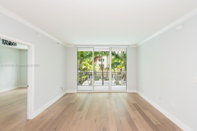 2000 N Bayshore Dr Unit 203, Miami, FL 33137 - empty room with ornamental molding, light wood-style flooring, and expansive windows