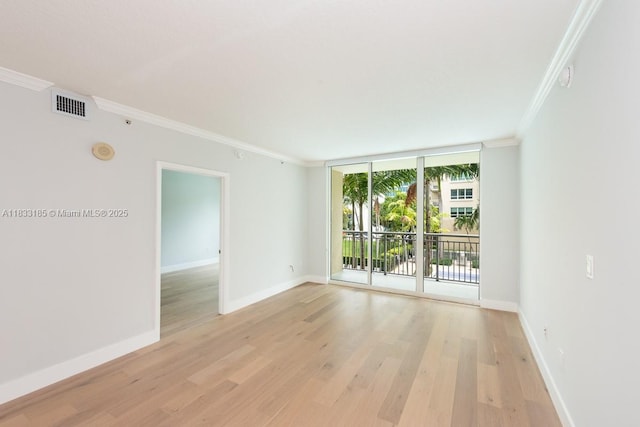 2000 N Bayshore Dr Unit 203, Miami, FL 33137 - empty room featuring ornamental molding, light wood-style flooring, expansive windows, and a smoke detector