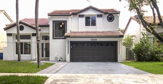 10204 Caracas St, Cooper City, FL 33026 - view of front of home with stucco siding, concrete driveway, and an attached garage