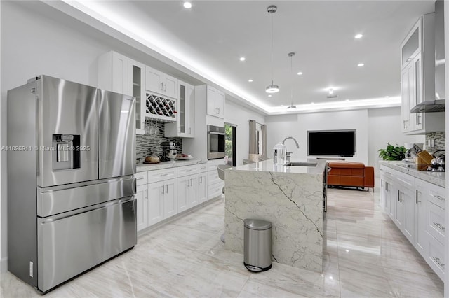 7970 SW 26th St, Miami, FL 33155 - kitchen featuring appliances with stainless steel finishes, wall chimney range hood, open floor plan, backsplash, and white cabinetry