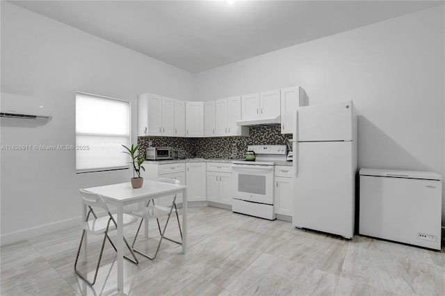7970 SW 26th St, Miami, FL 33155 - kitchen with white appliances, a wall unit AC, under cabinet range hood, white cabinetry, and backsplash