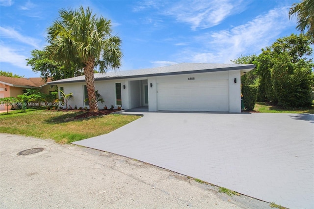 4808 Mango Dr, Tamarac, FL 33319 - view of front of home featuring stucco siding, a garage, driveway, and a front lawn