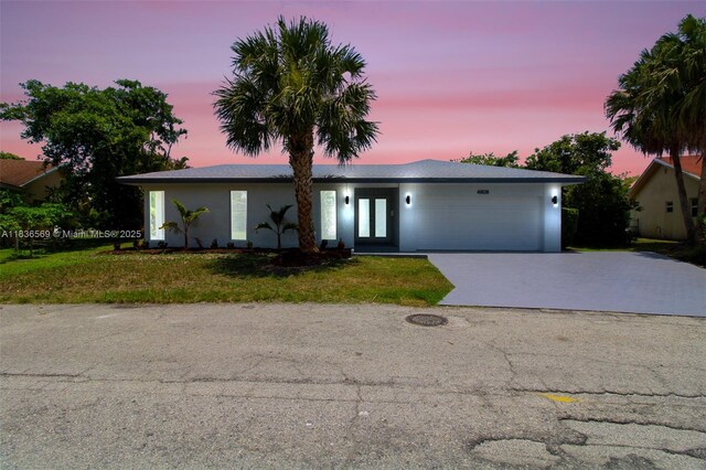 4808 Mango Dr, Tamarac, FL 33319 - view of front of home with a garage, a yard, concrete driveway, and stucco siding