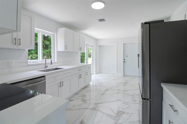 4808 Mango Dr, Tamarac, FL 33319 - kitchen featuring appliances with stainless steel finishes, light marble finish floors, white cabinetry, and light countertops