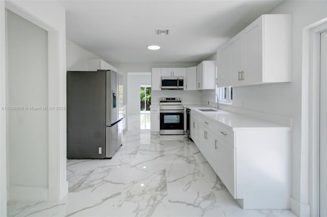4808 Mango Dr, Tamarac, FL 33319 - kitchen with stainless steel appliances, light marble finish floors, white cabinetry, light countertops, and recessed lighting