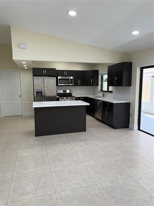 1061 NW 128th Ave, Miami, FL 33182 - kitchen featuring appliances with stainless steel finishes, dark cabinetry, light countertops, lofted ceiling, and a center island