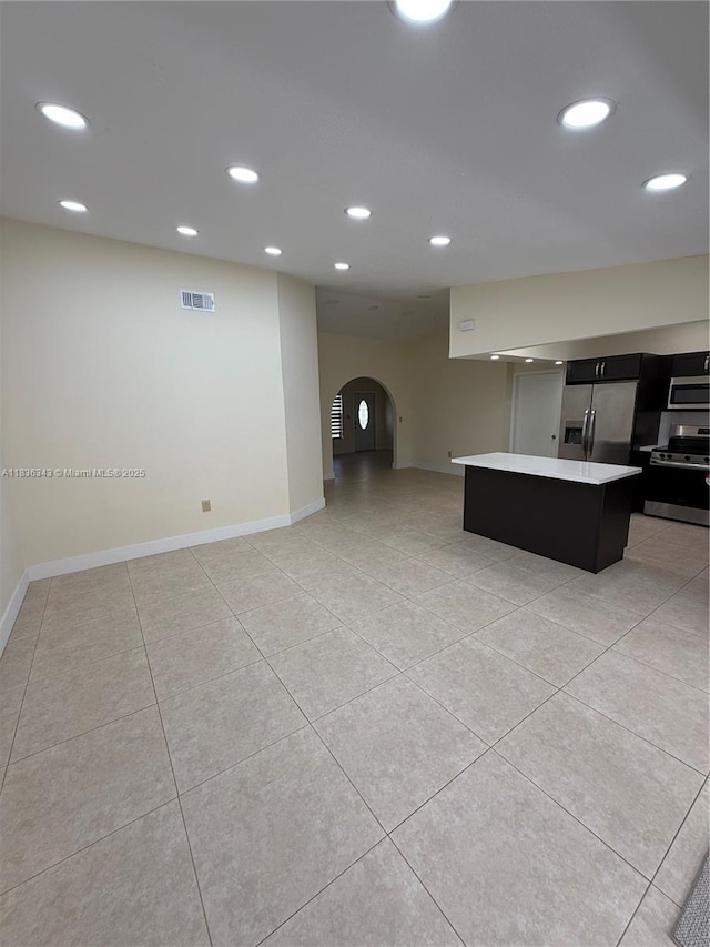 1061 NW 128th Ave, Miami, FL 33182 - kitchen with stainless steel appliances, arched walkways, light countertops, dark cabinetry, and a kitchen island