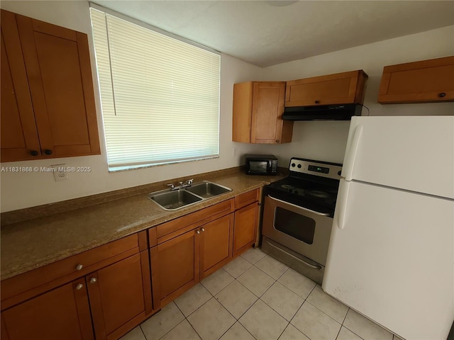 1750 NW 55th Ave Unit 103, Lauderhill, FL 33313 - kitchen with freestanding refrigerator, stainless steel range with electric cooktop, under cabinet range hood, and brown cabinetry