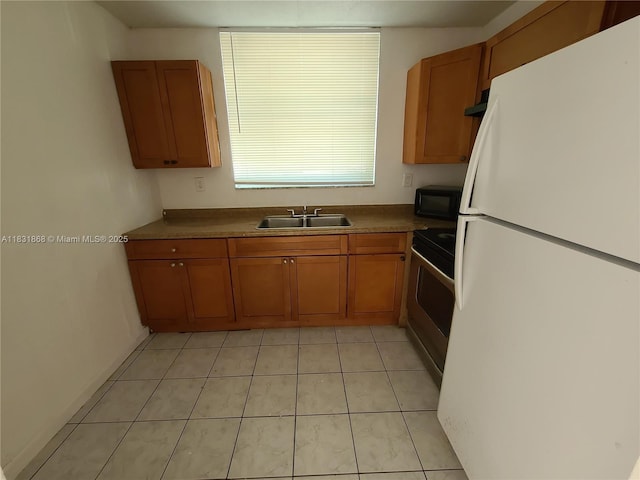 1750 NW 55th Ave Unit 103, Lauderhill, FL 33313 - kitchen featuring freestanding refrigerator, stainless steel range oven, brown cabinetry, black microwave, and light tile patterned floors