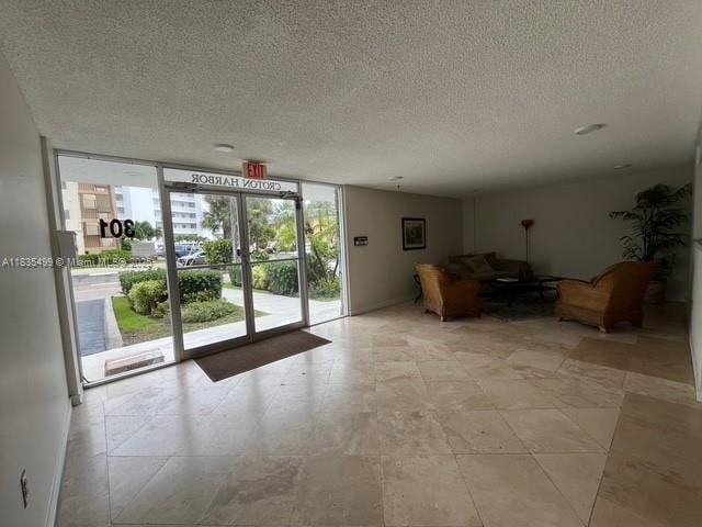 301 Croton Ave Unit 203, Lantana, FL 33462 - building lobby featuring floor to ceiling windows and a textured ceiling
