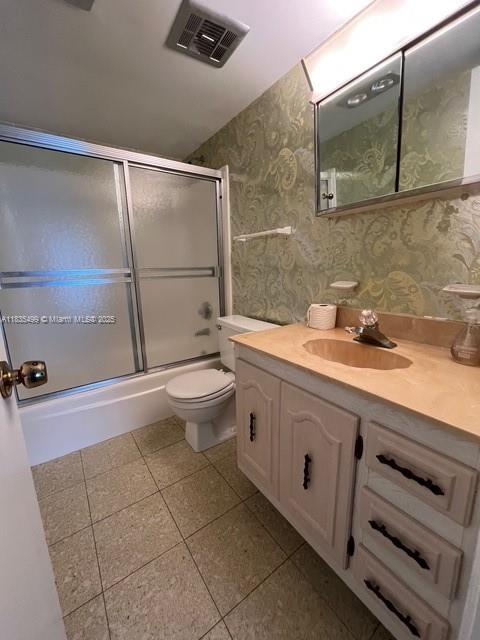 301 Croton Ave Unit 203, Lantana, FL 33462 - full bathroom with wallpapered walls, vanity, shower / bath combination with glass door, and tile patterned flooring