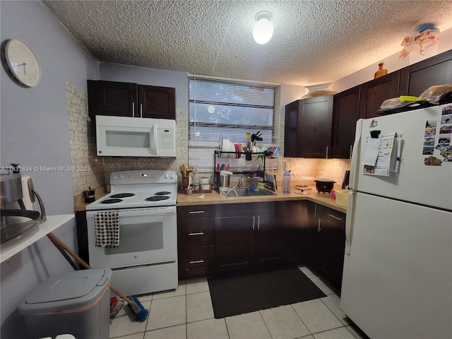 1796 NW 55th Ave Unit 103, Lauderhill, FL 33313 - kitchen featuring white appliances, light countertops, a textured ceiling, light tile patterned flooring, and dark brown cabinets