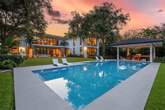 8875 SW 61st Ct, Pinecrest, FL 33156 - pool at dusk with a gazebo, a patio, an outdoor pool, and a yard