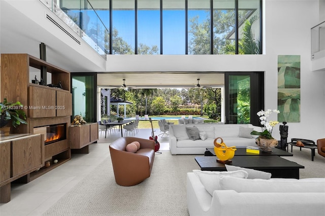 8875 SW 61st Ct, Pinecrest, FL 33156 - tiled living room with a high ceiling, a glass covered fireplace, and plenty of natural light