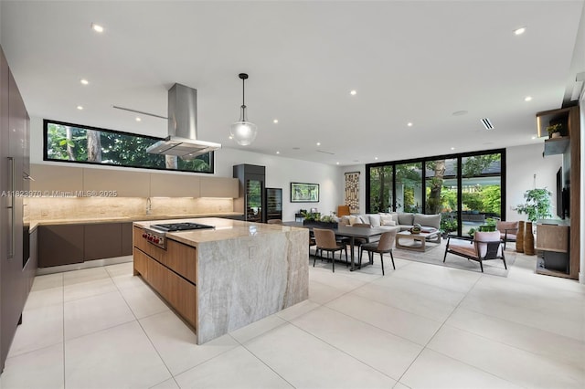 8875 SW 61st Ct, Pinecrest, FL 33156 - kitchen with modern cabinets, island exhaust hood, stainless steel gas stovetop, tasteful backsplash, and light stone countertops