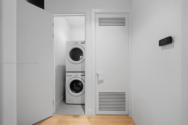 8875 SW 61st Ct, Pinecrest, FL 33156 - laundry area with stacked washing machine and dryer, a heating unit, and wood finished floors