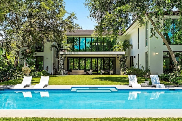 8875 SW 61st Ct, Pinecrest, FL 33156 - back of house featuring stucco siding, a yard, and an outdoor pool