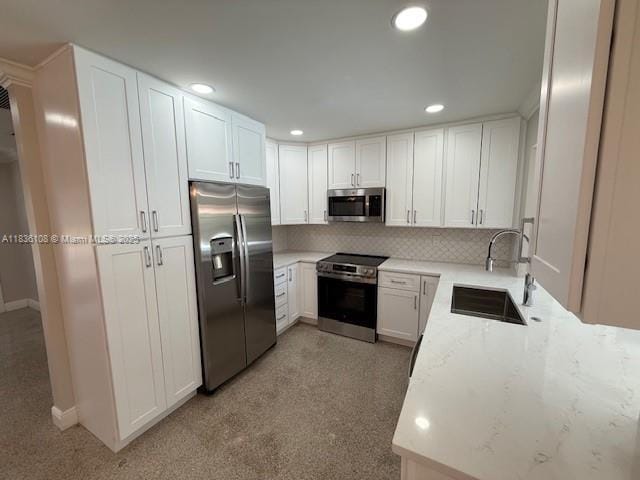 917 SE 15th Ct, Deerfield Beach, FL 33441 - kitchen featuring appliances with stainless steel finishes, backsplash, white cabinetry, recessed lighting, and light stone countertops