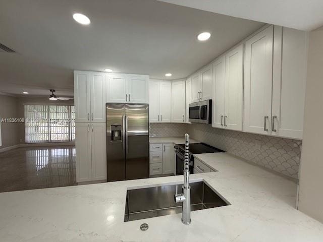 917 SE 15th Ct, Deerfield Beach, FL 33441 - kitchen featuring appliances with stainless steel finishes, light stone countertops, backsplash, recessed lighting, and white cabinetry