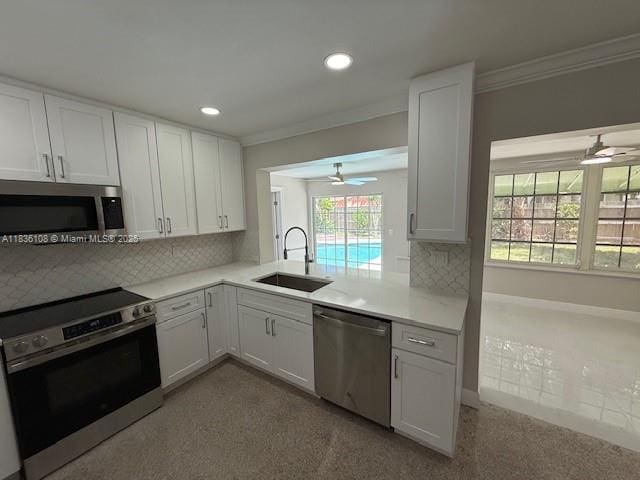 917 SE 15th Ct, Deerfield Beach, FL 33441 - kitchen featuring appliances with stainless steel finishes, a ceiling fan, crown molding, light countertops, and tasteful backsplash
