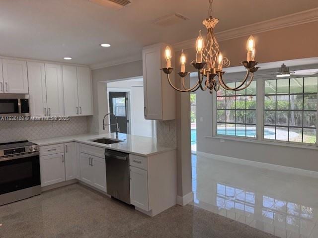 917 SE 15th Ct, Deerfield Beach, FL 33441 - kitchen featuring appliances with stainless steel finishes, ornamental molding, backsplash, light countertops, and white cabinetry