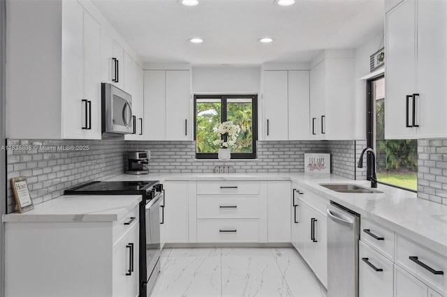 11965 SW 15th Ct, Davie, FL 33325 - kitchen with stainless steel appliances, recessed lighting, light stone countertops, light marble finish floors, and white cabinetry
