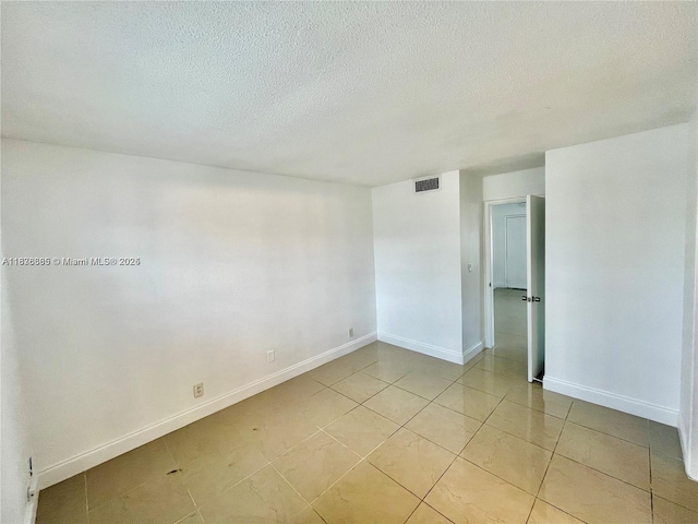 241 SE 9th Ave Unit 207, Pompano Beach, FL 33060 - spare room featuring a textured ceiling and light tile patterned flooring
