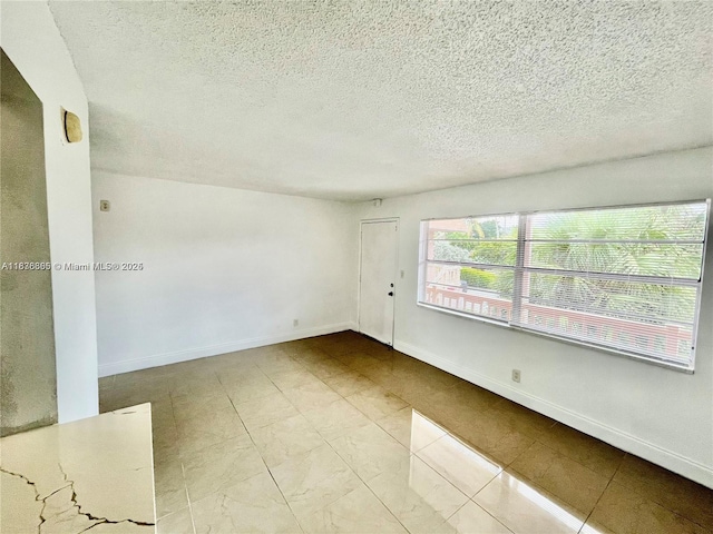 241 SE 9th Ave Unit 207, Pompano Beach, FL 33060 - unfurnished room featuring a textured ceiling and baseboards