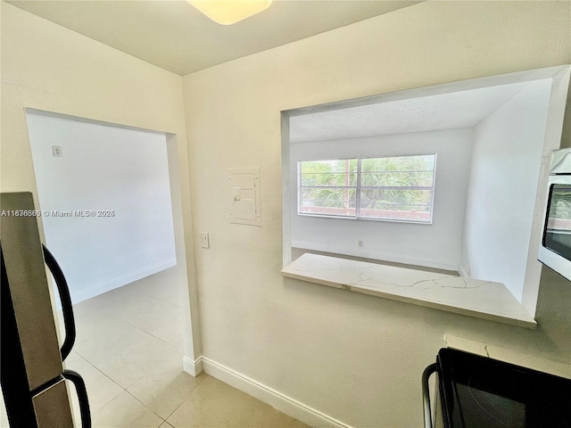 241 SE 9th Ave Unit 207, Pompano Beach, FL 33060 - interior space with light stone counters, light tile patterned floors, wall oven, and freestanding refrigerator
