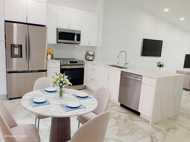 6128 N Kings Gate Cir, Delray Beach, FL 33484 - kitchen featuring appliances with stainless steel finishes, light marble finish floors, white cabinetry, recessed lighting, and light countertops