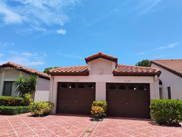 6128 N Kings Gate Cir, Delray Beach, FL 33484 - mediterranean / spanish-style house featuring a tiled roof, stucco siding, and an attached garage