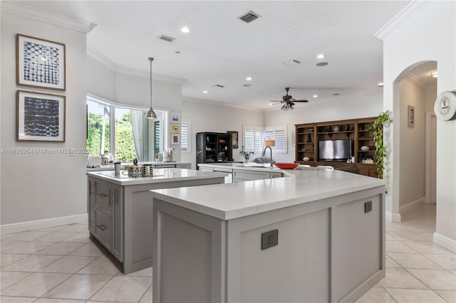 12530 SW 96th Ct, Miami, FL 33176 - kitchen featuring a large island, gray cabinetry, light tile patterned floors, arched walkways, and light countertops