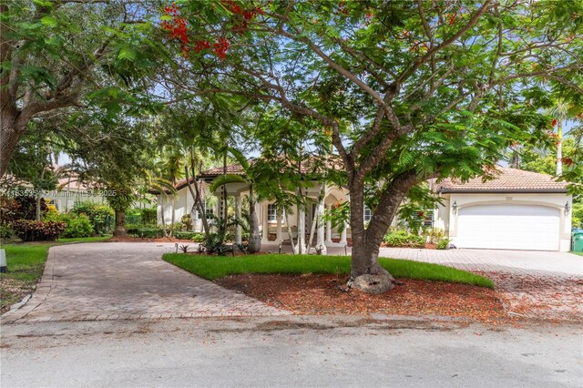 12530 SW 96th Ct, Miami, FL 33176 - mediterranean / spanish house with decorative driveway, stucco siding, an attached garage, and a tile roof