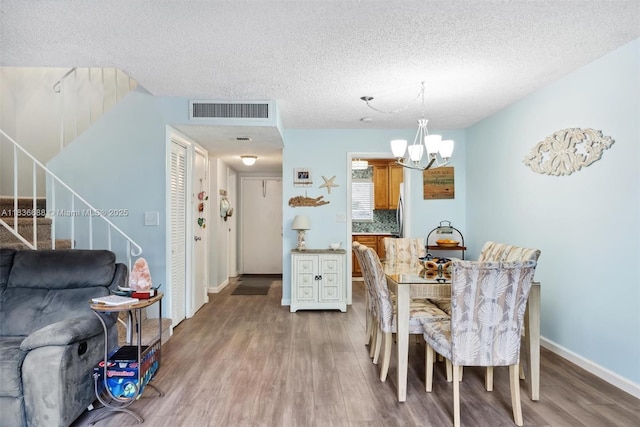 3300 Atlanta St, Hollywood, FL 33021 - dining area featuring wood finished floors, a textured ceiling, stairway, and a chandelier