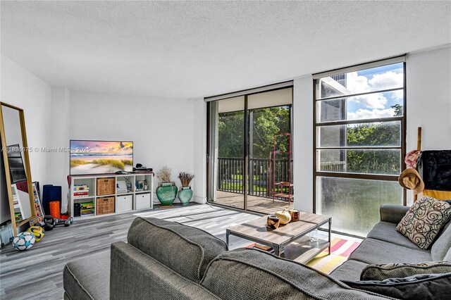 3401 N Country Club Dr Unit 308, Aventura, FL 33180 - living area featuring expansive windows, wood finished floors, and a textured ceiling