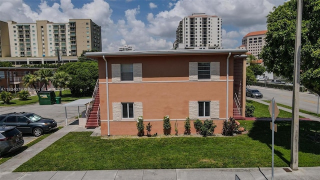 3600 SW 9th Ter Unit 1B, Miami, FL 33135 - view of home's exterior featuring stairway, stone siding, stucco siding, and a yard